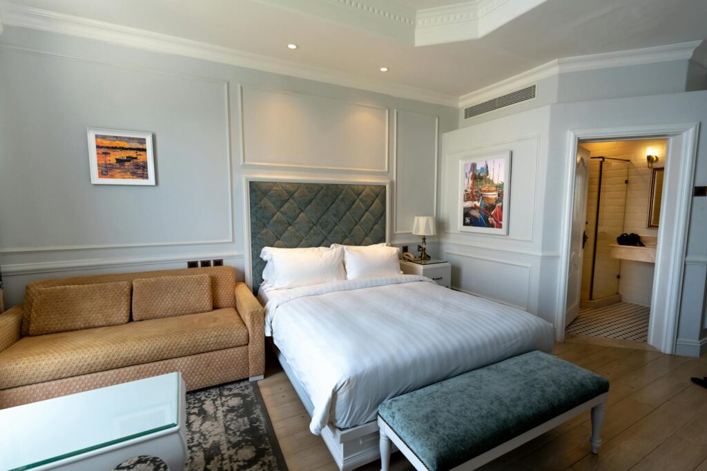 A stylish hotel room featuring a cozy bed, sofa, and luxurious decor.