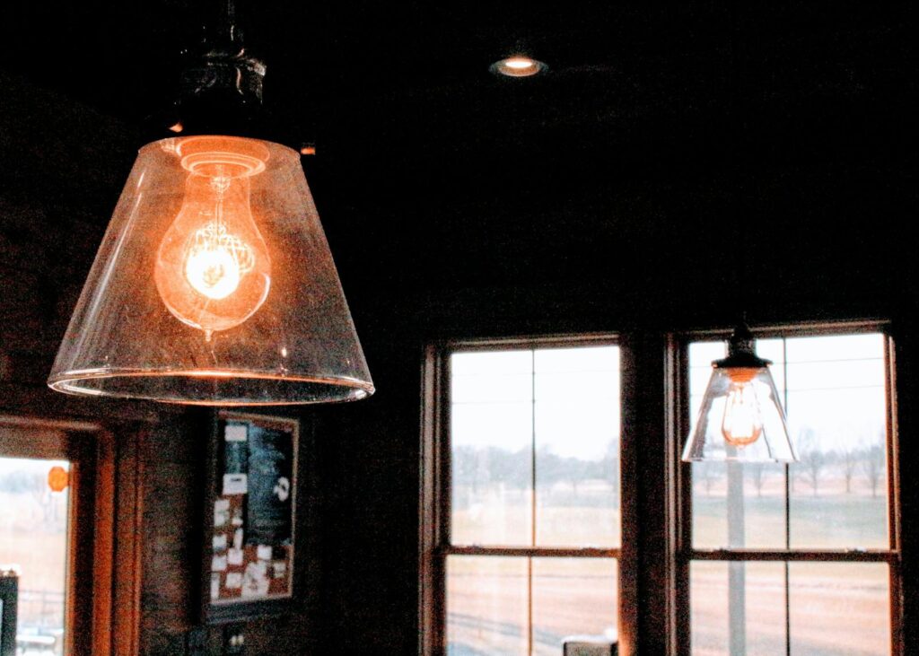 Illuminated vintage-style bulbs in cozy indoor setting with natural light.